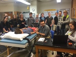 Michigan Tech students demonstrate arterial stiffness measurements to high school students.