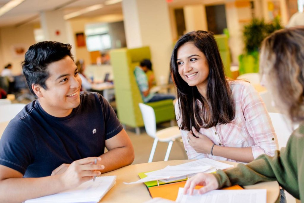 Three Michigan Tech business students at campus library.