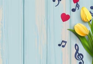 Music notes and yellow tulips on blue wooden background.