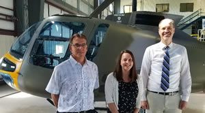 Enstrom employees in front of a helicopter