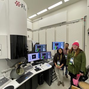 Erico and students standing near computer monitors in the lab.