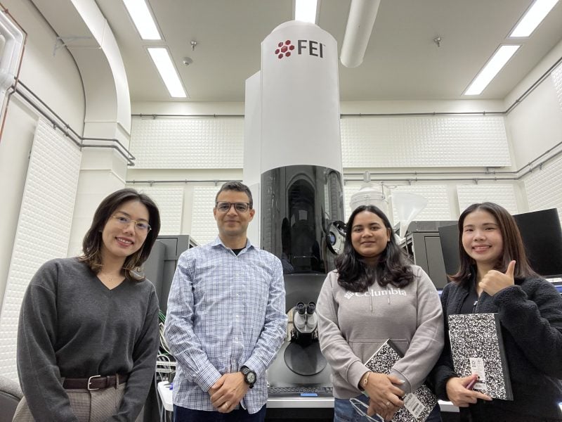 Four people standing in front of a large machine.