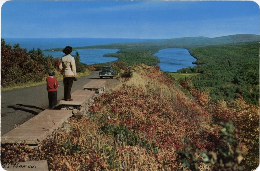 Circa 1951, wo people stand on the roadside atop Brockway Mountain overlooking Lake Superior.
