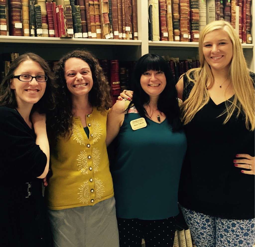 The Archives public services team poses for a final photograph. The ladies stand in front of volumes from the historic state records collection. From left to right are Allyse Staehler, Airen Campbell-Olszewski, Alison Fukuchi, and Georgeann Jukuri.