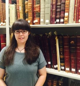 Our new team member, Emily Riippa, poses in the stacks at the end of her first week. 