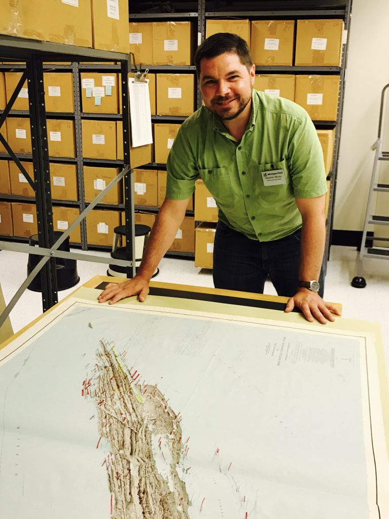 Steve Moray assesses a map of Isle Royale in the archives stacks. 