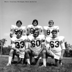 Michigan Tech football players pose on the field, 1974.