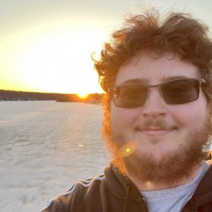 Tucker Nielsen stands in front of a sunset.