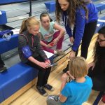 Erin and Colleen teaching students how to measure the blood oxygen saturation using a pulse oximeter.