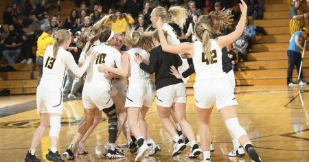 Women's basketball team jumping and hugging on the court