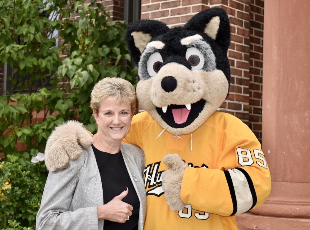 Associate Dean of Business and Economics poses alongside Blizzard, Michigan Tech's mascot