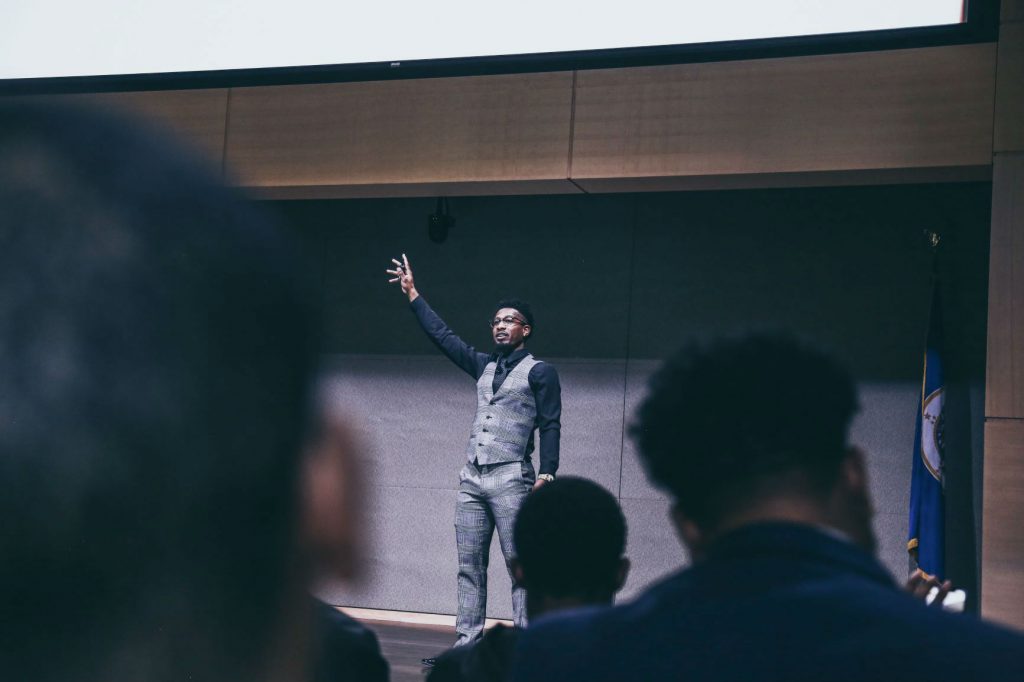 Speaker Donzell Dixson stands before an audience