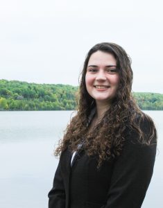 student stands in front of canal