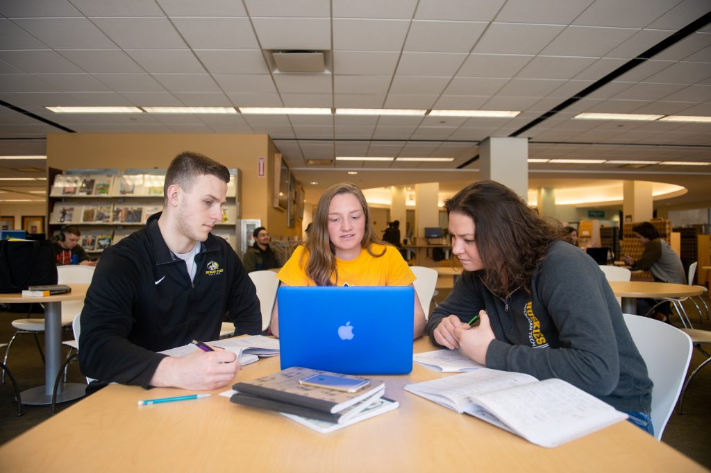 Three students in library with Apple computer