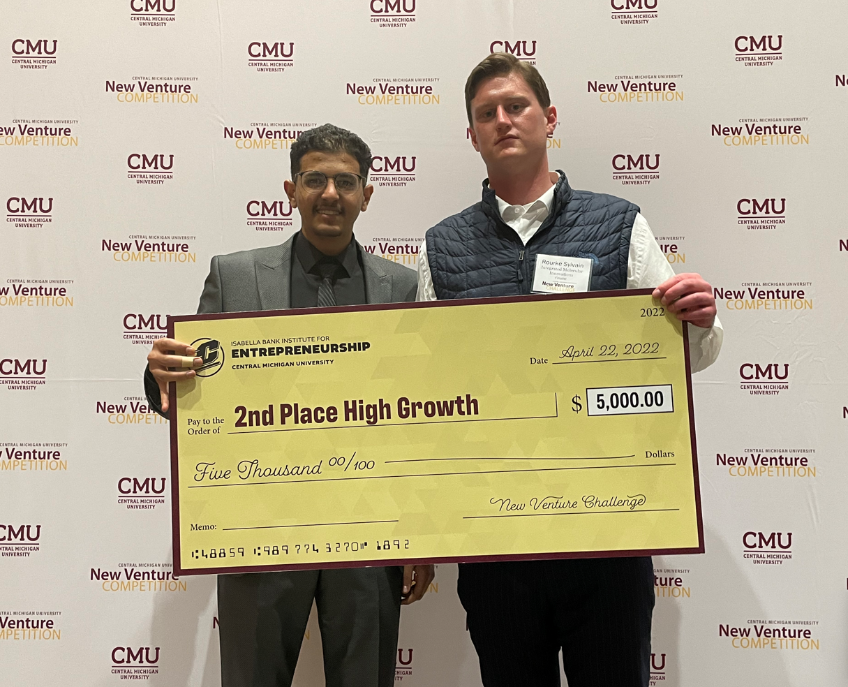 MTU student Ali Dabas and Rourke Sylvain posing with a large check