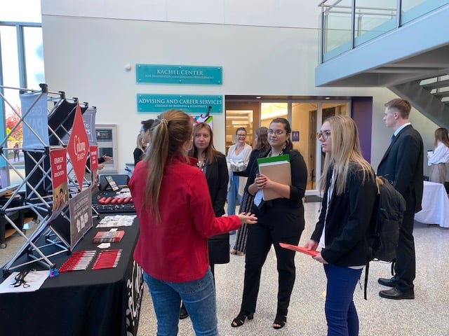 Two students speaking with a company rep