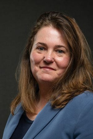 A portrait of an award-winning faculty member in Michigan Tech’s College of Business with a neutral background behind her.