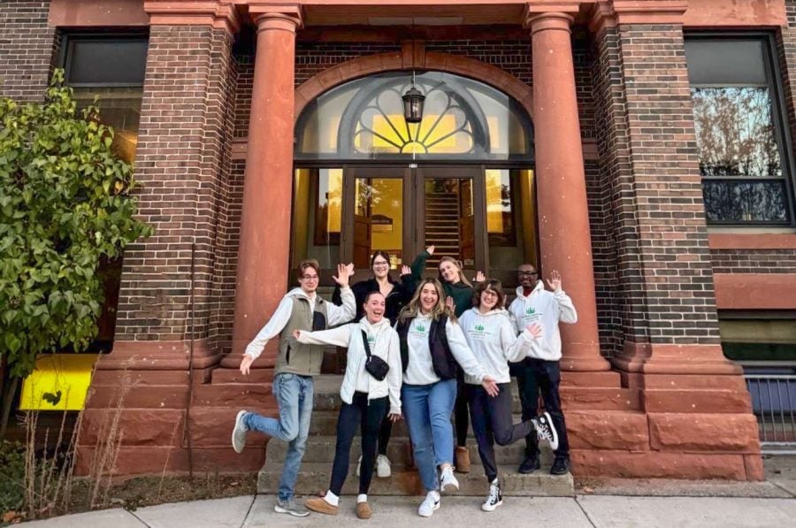 AMA students outside the College of Business building in their AMA merch, posing as a group.