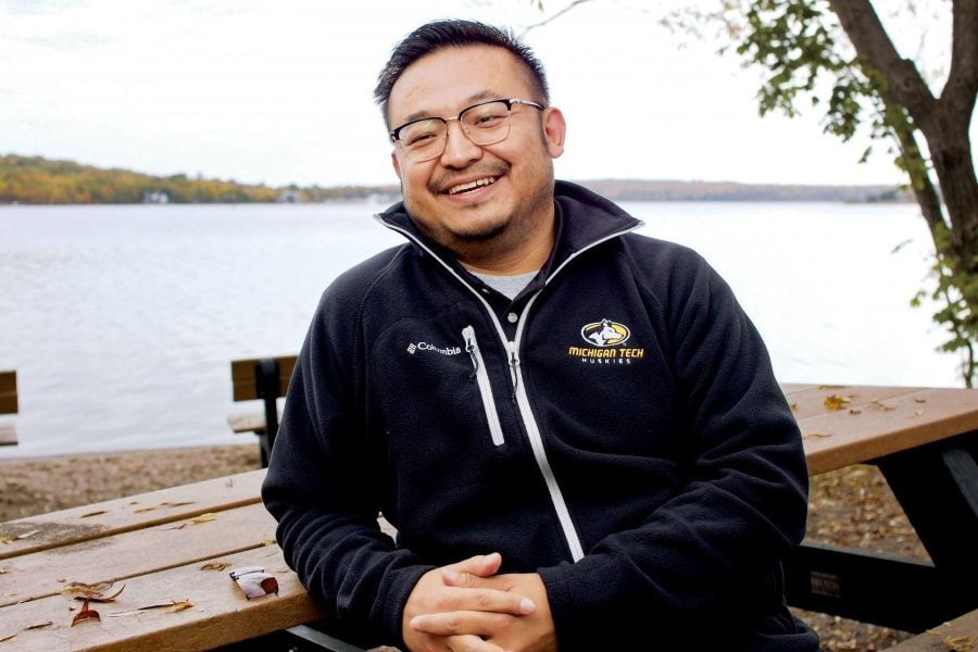 Peipei Zhao ’09 smiling near the Keweenaw Waterway on Prince’s Point on the Michigan Tech campus, in Tech attire.