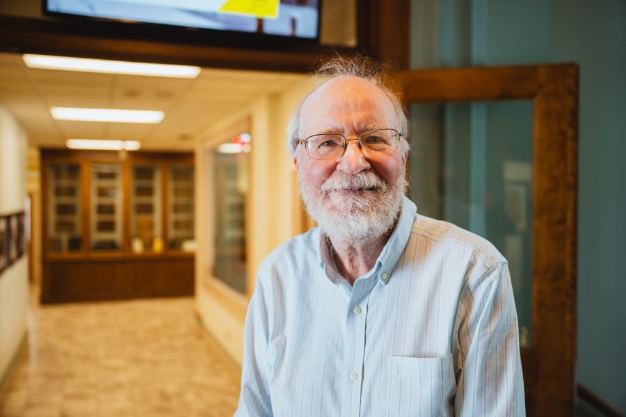 A smiling professor in the halls of the College of Business at Michigan Technological University.