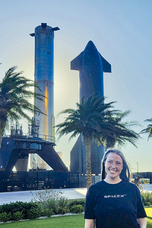 A young engineer stands outdoors at SpaceX Starship headquarters.
