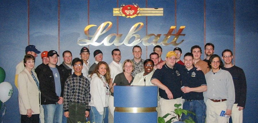 A group of students and their professor stand under a Labatt’s sign in Toronto, Ontario in 2004.