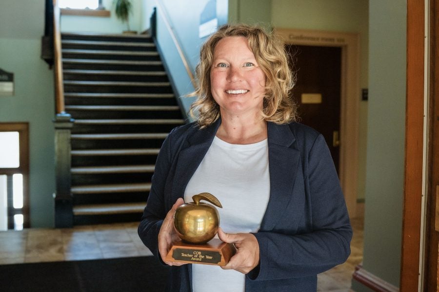 Jodie Dompier of Michigan Tech’s College of Business holds the golden apple statuette she earned as the College’s 2026 Teacher of the Year.