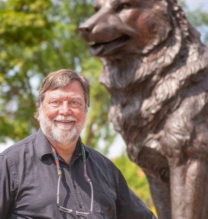 Michael Mullins standing outside in campus near the Husky Statue