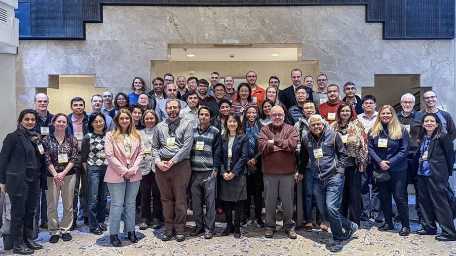 Four rows of smiling computer leadership academy participants smile for the camera with a neutral background behind them at Westin City Center in Washington, D.C.