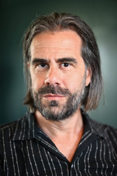 Professional in-studio headshot of Ian Bogost with a blue background