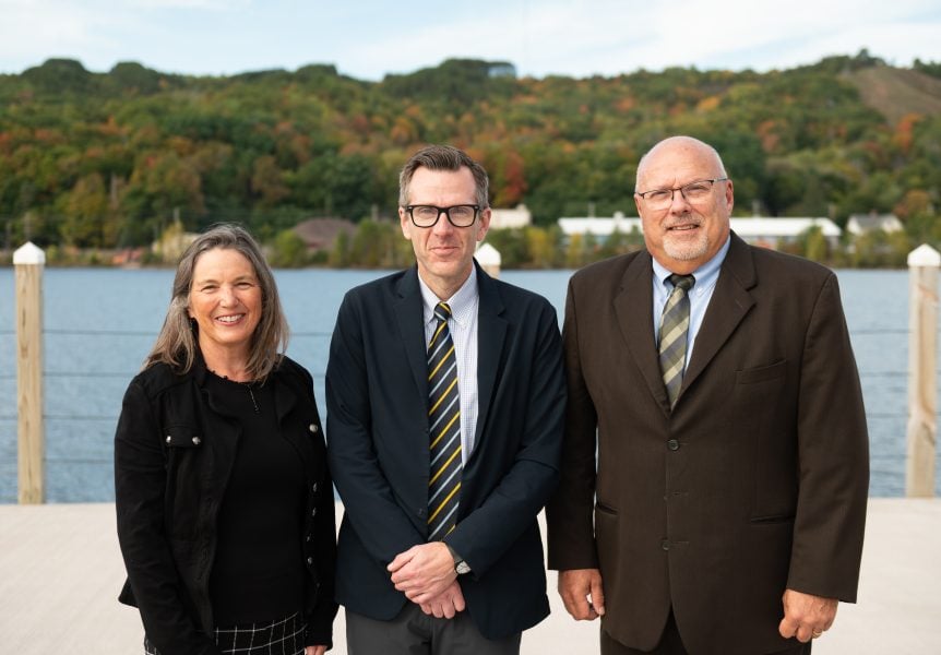 Dennis Livesay, Mark Gauthier, and Dianne Marsh from the Michigan Tech College of Computing pose in front of the Portage Canal before the Honor Academy inductee dinner.