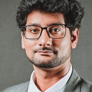 Dr. Neerav Kaushal headshot with metropolitan buildings in the background
