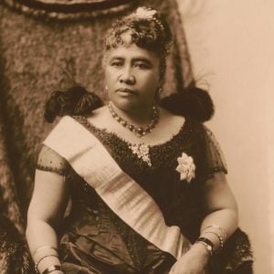 Official portrait of Queen Lili‘uokalanin wearing a dress, sash and broach.