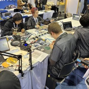 Students at a table working on circuit boards