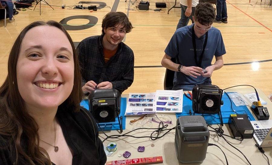 Katelyn Spolnicki and Alex Ossenheimer with a student in a gymnasium using electrical equipment