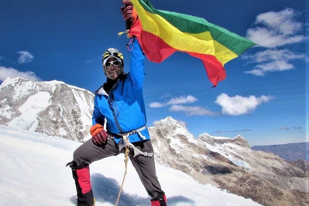 Sirak Seyoum waves the Ethiopian flag atop Mt Chopicalqui, Peru (2015)