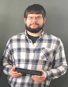 Sam Dlugoss holds a version of the finished nameplate