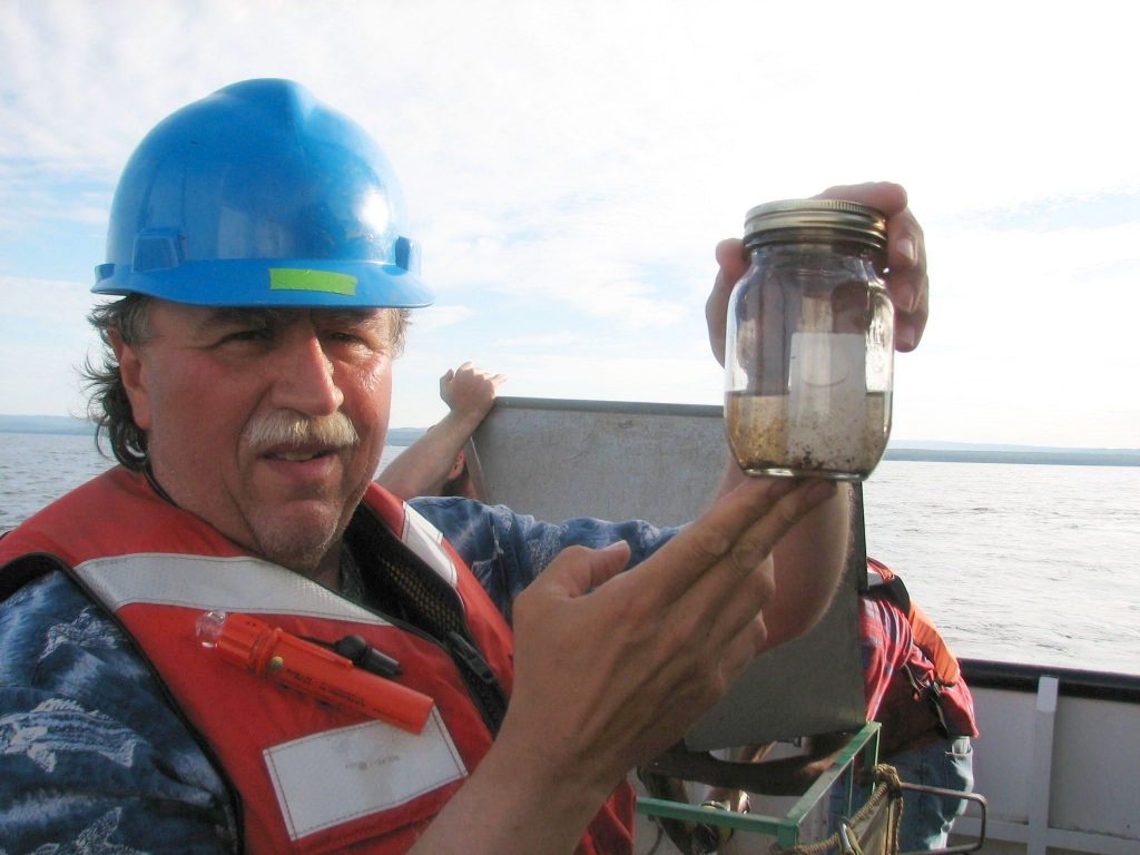 Dr. Martin Auer, Michigan Tech Civil and Environmental Engineering Professor Emeritus hold us a test capsule on board a research vessel on Lake Superior