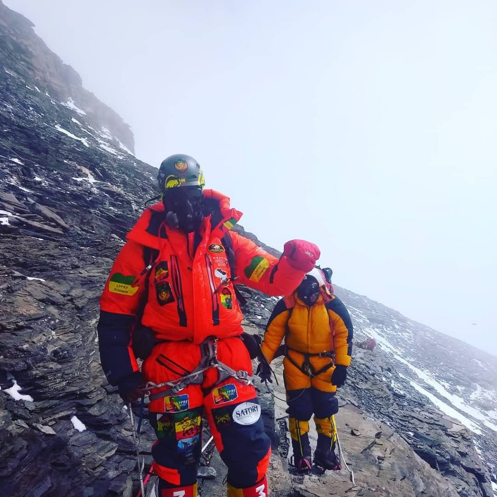 Crossing the Geneva Spu with oxygen mask onr, on exposed rocky sections. Around the bend is Camp 4.