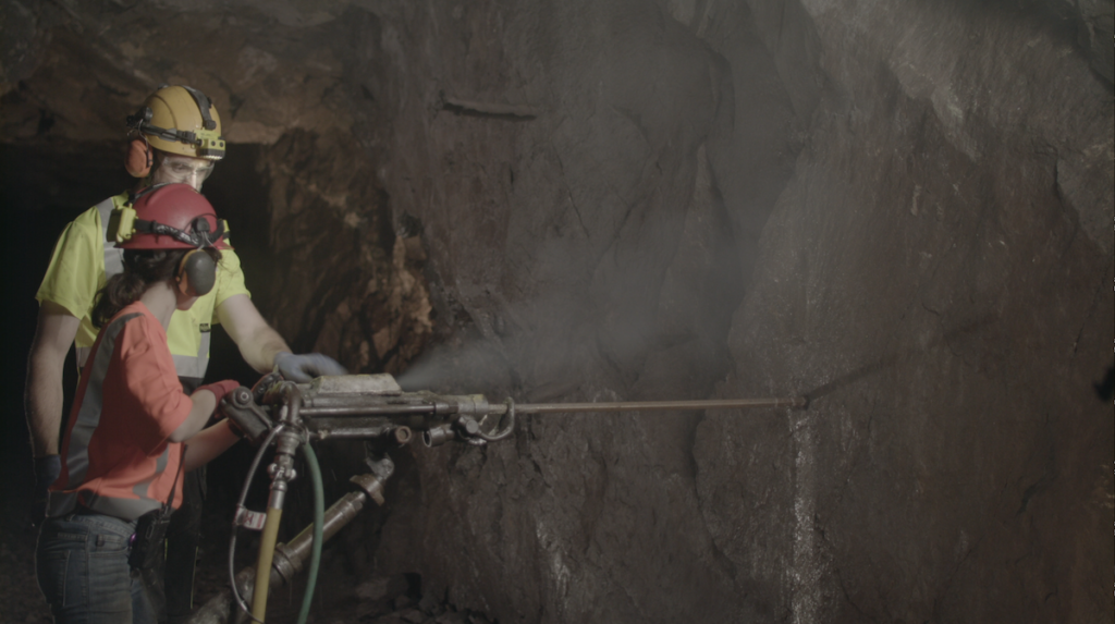 Matt Portfleet shows safe rock drilling practices to geology major Elana Barth in the Adventure Mine. Photo courtesy of Matt Portfleet.