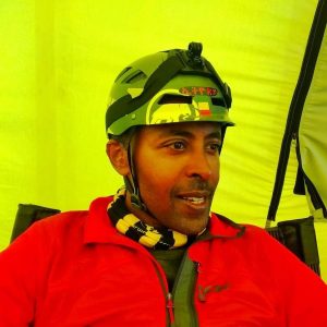 A head and shoulders photo of Sirak with yellow tent behind him, at Everest Base Camp for the first time, sitting in the dining room.