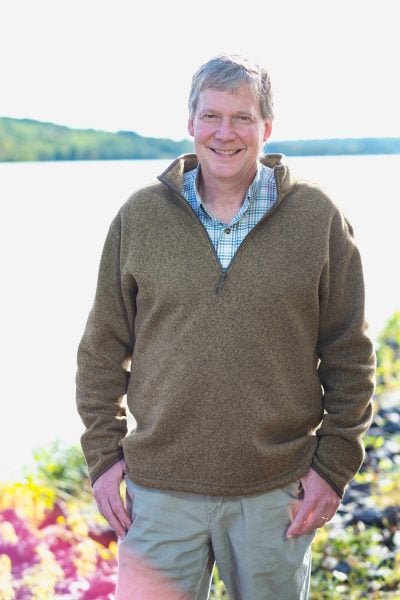 John Gierke stands with water behind him, on the shore of Portage Canal.