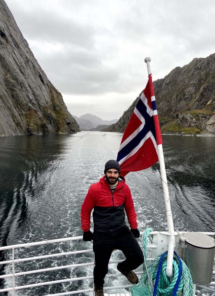 Estafanio on a boat with the Norweigan flag hanging above him.