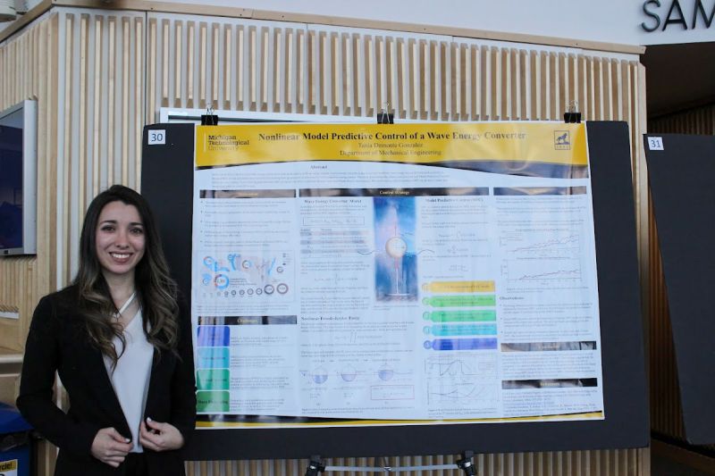 Researcher standing by her poster.