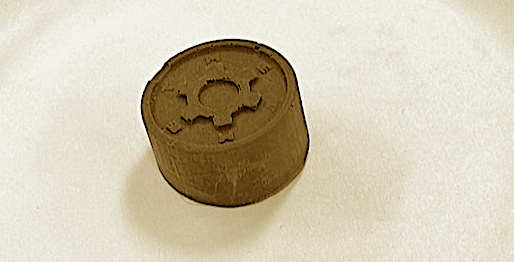 round disc-shaped chocolate with gear or wheel shape on top