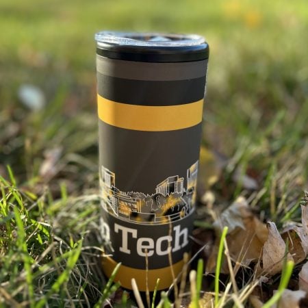 Tumbler with the word Tech and part of a campus buildings sketch visible standing in the grass.