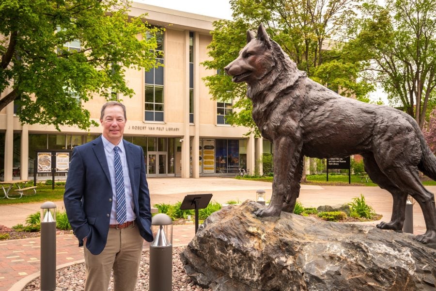 Jason Blough standing next to the Husky Statue.