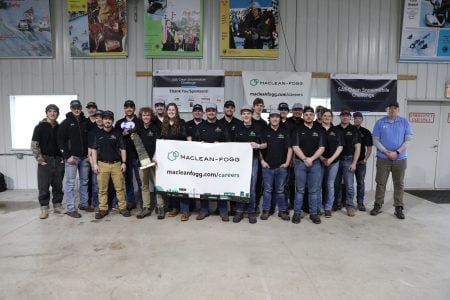 The SAE Clean Snowmobile Challenge team poses with the first-place trophy and sponsor banner after their win at the annual competition. 