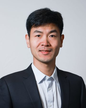 Zhengpeng (Jason) Wan poses in a professional portrait wearing a light blue collared shirt with a navy blazer.