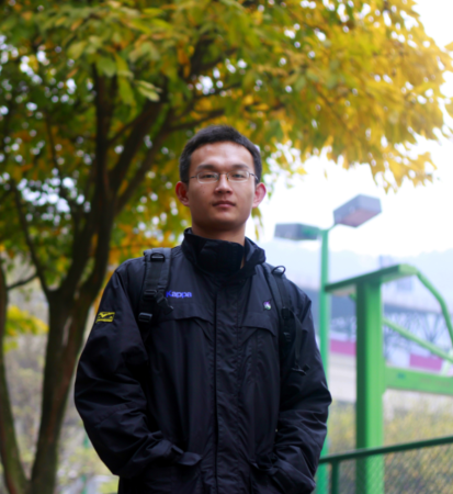 Yi Hu poses outside wearing a black jacket and backpack